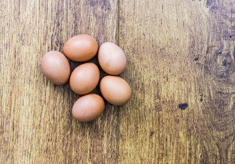Half a dozen brown eggs on a wooden background