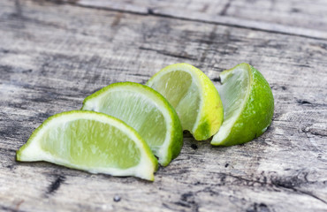 Slices of green lime on a wooden table