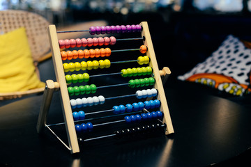 Educational colorful wooden abacus beads on table background. School arithmetic symbol, calculating thinking concept, closeup photography