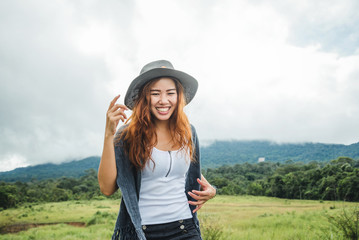 Asian women travel relax in the holiday. on a green pasture.