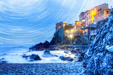Ligurian town during the blue hour..Beach Genoa Quinto during the blue hour, star trail in the background..