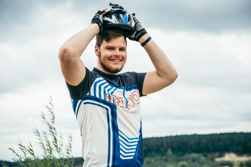 man near standing near lake with bicycle and check helmet