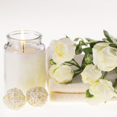 Plakat Spa. Burning candle, white roses and a towel on a white background
