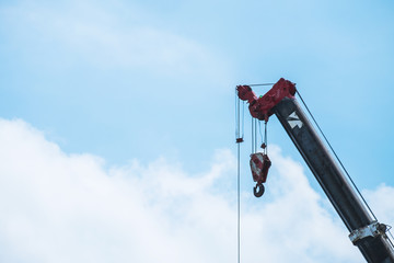 A large crane is working on blue sky background