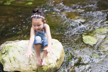 Little girl playing in the mountain stream