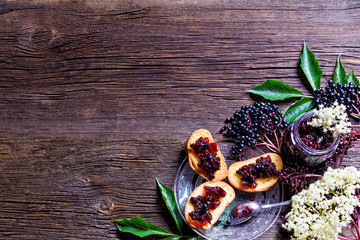 Toasts with elderberry jam and fresh berry fruits on wooden table. Free space for your text.