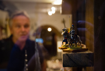 Man looking at tin toy soldier in shop