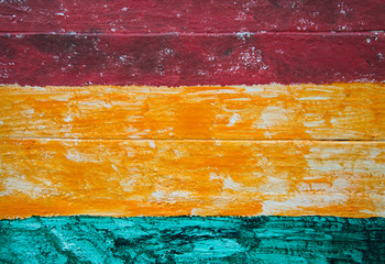 dark red, orange and green blue stripes on wood panel background