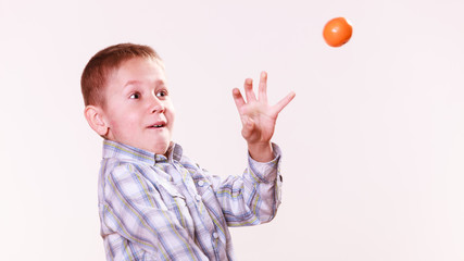 Young boy play with fruit