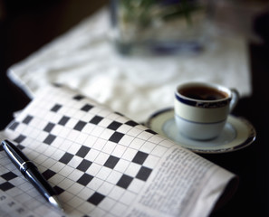 crossword puzzle with pen and black coffe