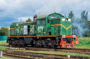 Fototapeta na wymiar Green shunting locomotive on railway tracks