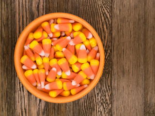 Delicious Fall/Halloween Themed Candy Corn in a Bowl on a Decorative Wooden Background