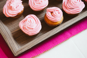 freshly baked muffins cupcakes on a natural wooden board