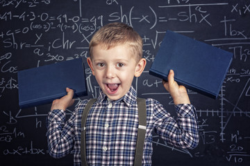 Caucasian child with plaid shirt and braces in front of a classic slate school blackboard. happy...