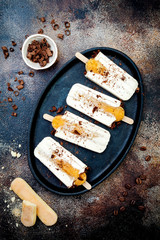 Tiramisu popsicles. Ice pops with italian savoiardi cookies and tiramisu ingredients on rustic kitchen table. Top view, overhead, flat lay