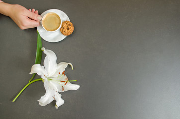 Mão de mulher tomando café, com cookies, visto de cima