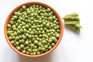 Green peas and pod nearby