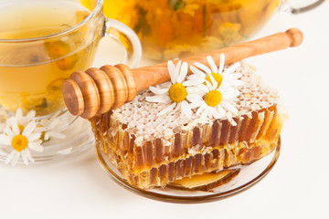 Honeycomb and chamomile tea on white