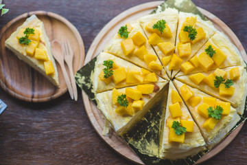 close up mango crepe with fresh mango, creamy mango mousse cake on a white wood background. toning. selective focus, Mango cheesecake on white plate with fork