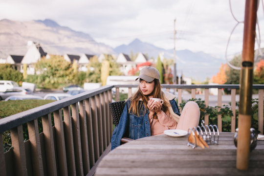 Young hipster woman chilling by the balcony at home in Queenstown, New Zealand