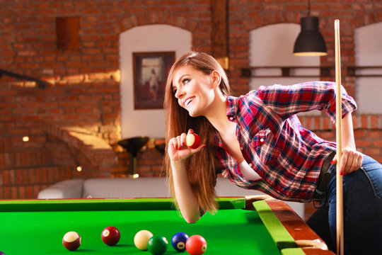 Young woman having fun with billiard.