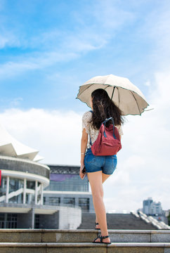 Woman Walking Up Stairs With Umbrella As Sun Protection