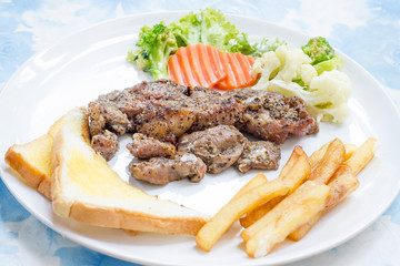 Grilled steak with french fries and vegetables and toast