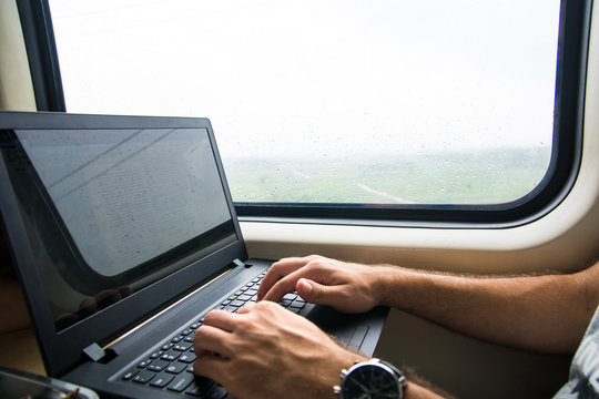 Man Working On Laptop In A Train