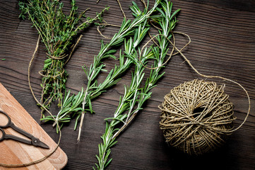 thyme and rosemary on wooden background top view