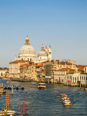 Fototapeta premium Grand Canal with boats and gondolas and the Basilica di Santa Maria della Salute in the background (Venice, Italy)
