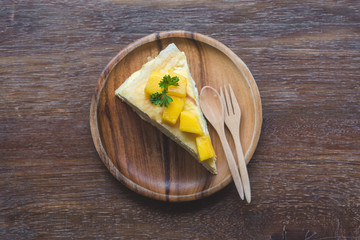 Fototapeta na wymiar close up mango crepe with fresh mango, creamy mango mousse cake on a white wood background. toning. selective focus, Mango cheesecake on white plate with fork