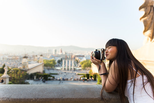 Eurasian woman with a vintage polaroid camera in Barcelona