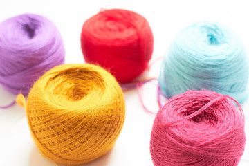 The balls of bright colored threads on the table