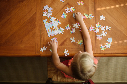 Young girl puts together puzzle