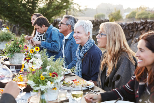 Group of friends enjoying a Farm To Table Dinner Party in backyard