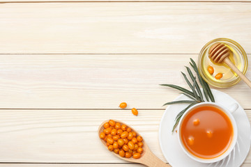 Sea buckthorn in wooden bowl, honey, Sea buckthorn juice on wooden table. top view with copy space