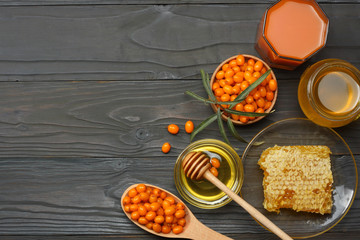 Sea buckthorn in wooden bowl, honey, Sea buckthorn juice on wooden table. top view with copy space
