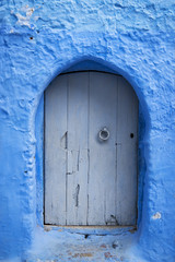 Detail of a wood door painted in blue in the beautiful town of Chefchaouen in Morocco, North Africa