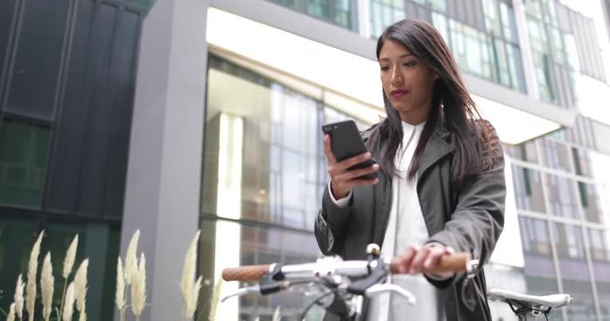 Businesswoman with bicycle and smartphone
