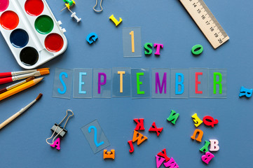 September 1st. Day 1 of month, Back to school concept. Calendar on teacher or student workplace background with school supplies on blue table. Autumn time