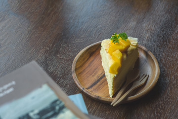 close up mango crepe with fresh mango, creamy mango mousse cake on a white wood background. toning. selective focus, Mango cheesecake on white plate with fork