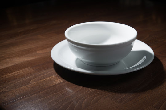 white empty plates on a dark wooden table