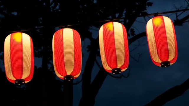 Paper red-white japanese lanterns Chochin shines on dark sky