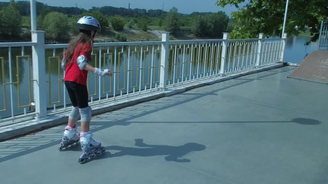 The child learns to skate. A little girl on the rollers.