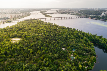 Panoramic view of Kiev city with the Dnieper River in the middle. Aerial view of the residential district and industrial Zone at sunset. Two banks of the river connected by bridges