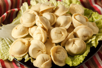 Frozen dumplings on the white plate with green