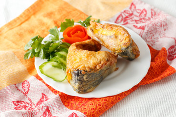 fish in batter with greens on a white plate