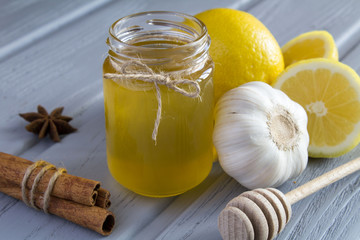 Honey, lemon and garlic on the grey wooden background 