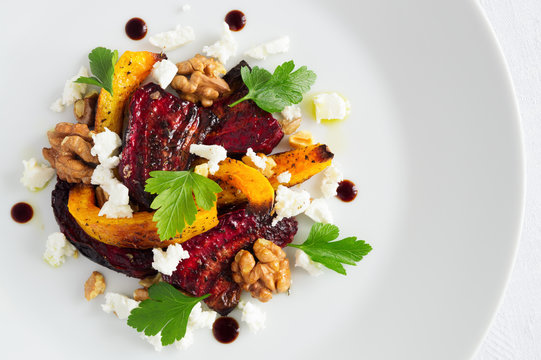 roasted beetrot, pampkin and walnuts with feta cheese decorated with parsley leafs and modena balsamic cream