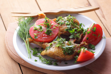 Roasted duck legs with tomato and herbs with wooden cutlery
